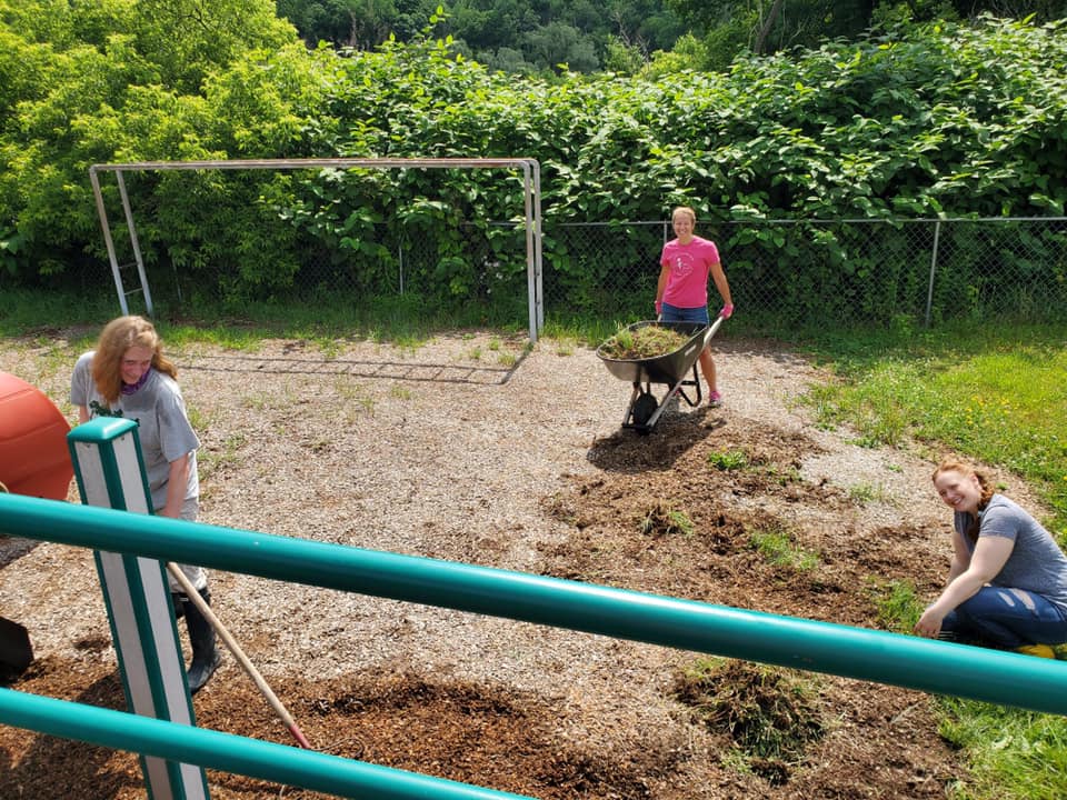 Volunteers Anna Kruzinski (right) and Sarah Poole (center) work with Council Member, Janet Tweed (left) to weed the Delhi playground.